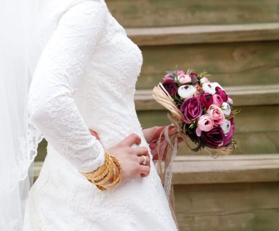 Bride holding a bouquet, dress detail